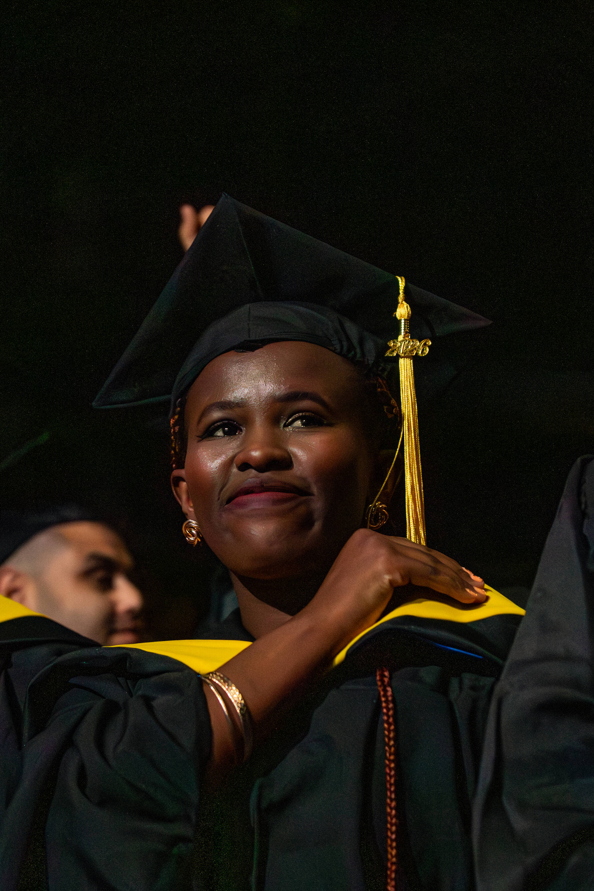 student in black robe on graduation stage